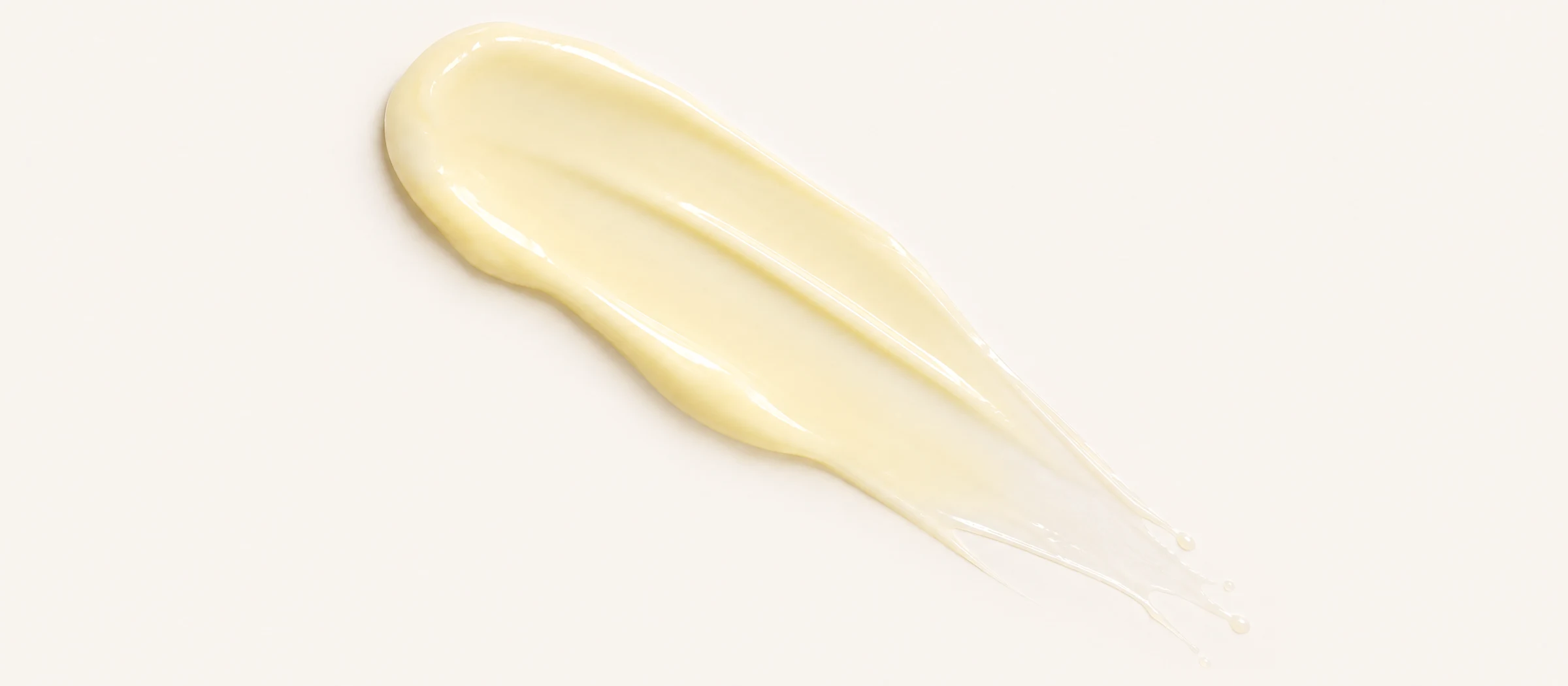 A swipe of SEISUI's pale-yellow retinal night cream showing its rich, glossy texture